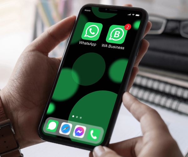 office worker hands holding a phone with WhatsApp and WhatsApp Business installed on it