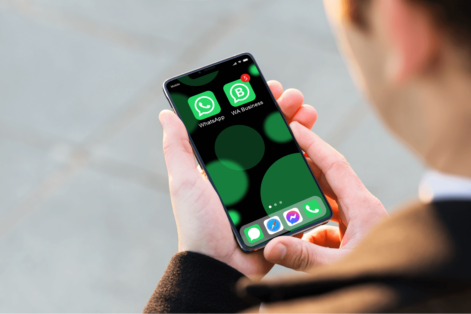 office worker hands holding a phone with WhatsApp and WhatsApp Business installed on it