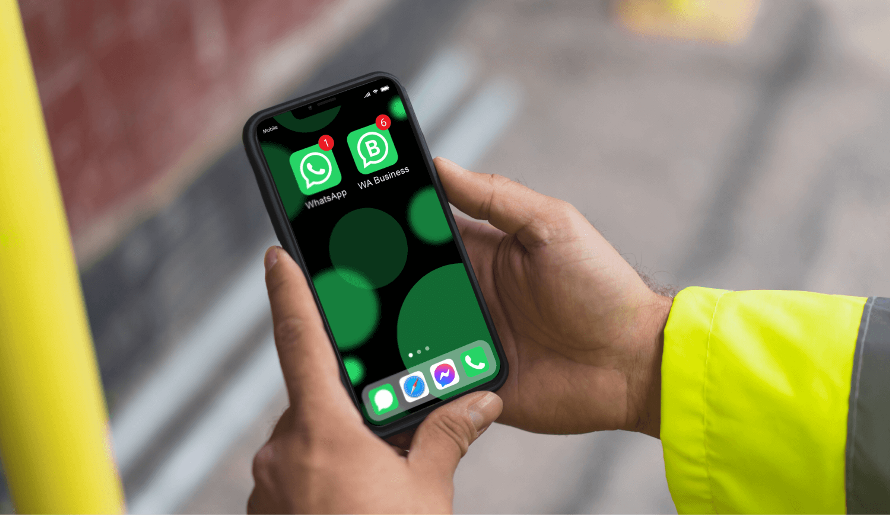 Construction worker hands holding a phone with WhatsApp and WhatsApp Business installed on it