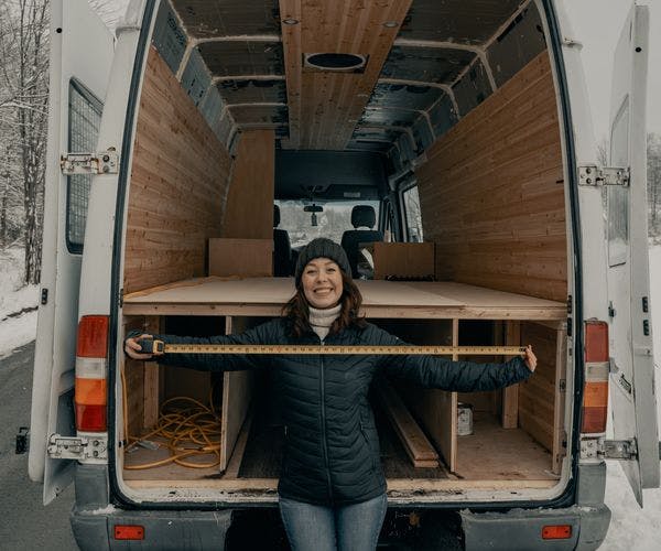 Woman installing wooden panels in a van