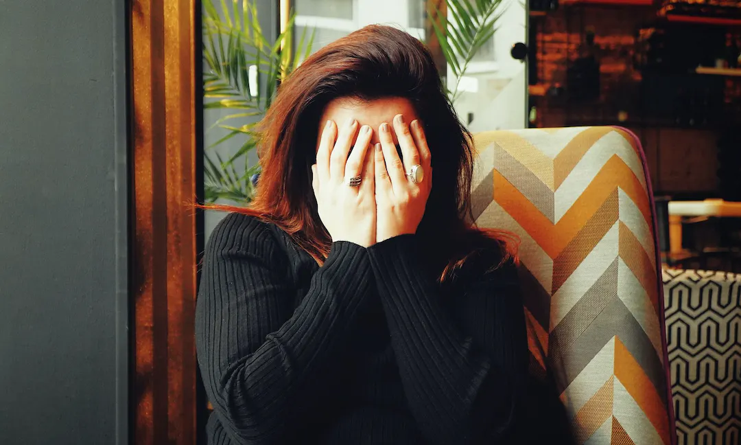 Woman covers face with hands