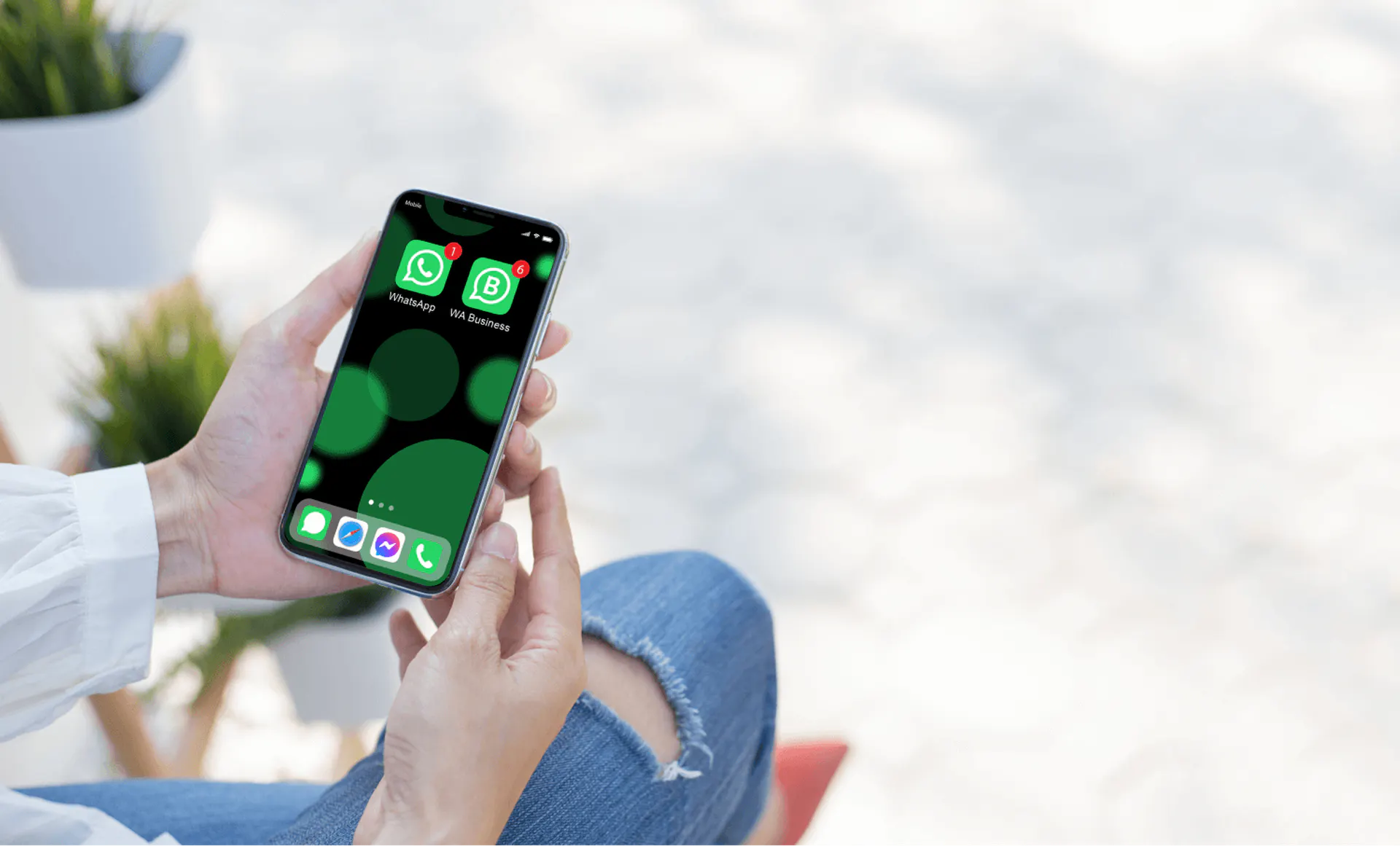 Female hands holding a phone with WhatsApp and WhatsApp Business installed on it