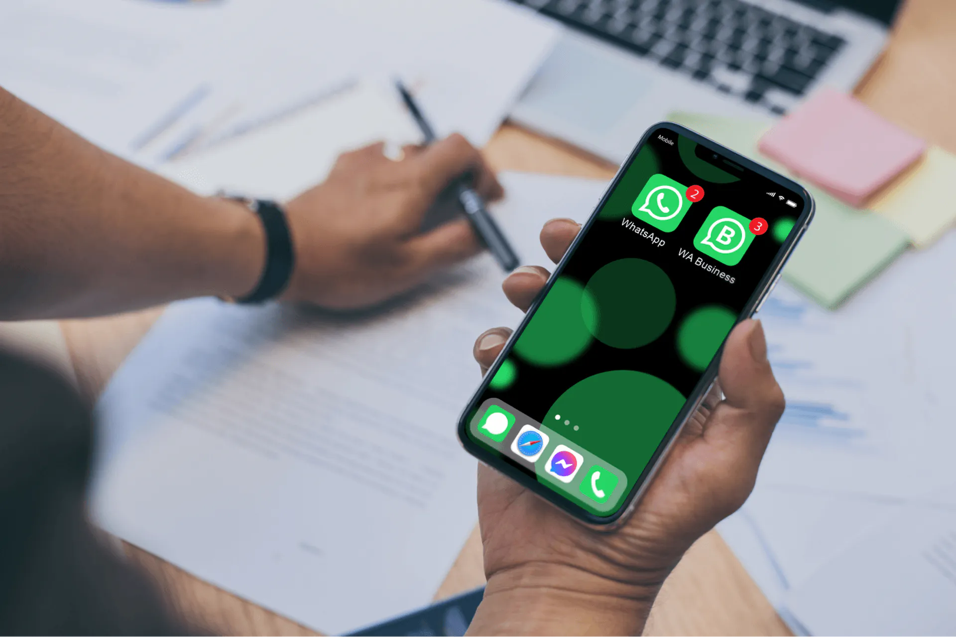 office worker hands holding a phone with WhatsApp and WhatsApp Business installed on it